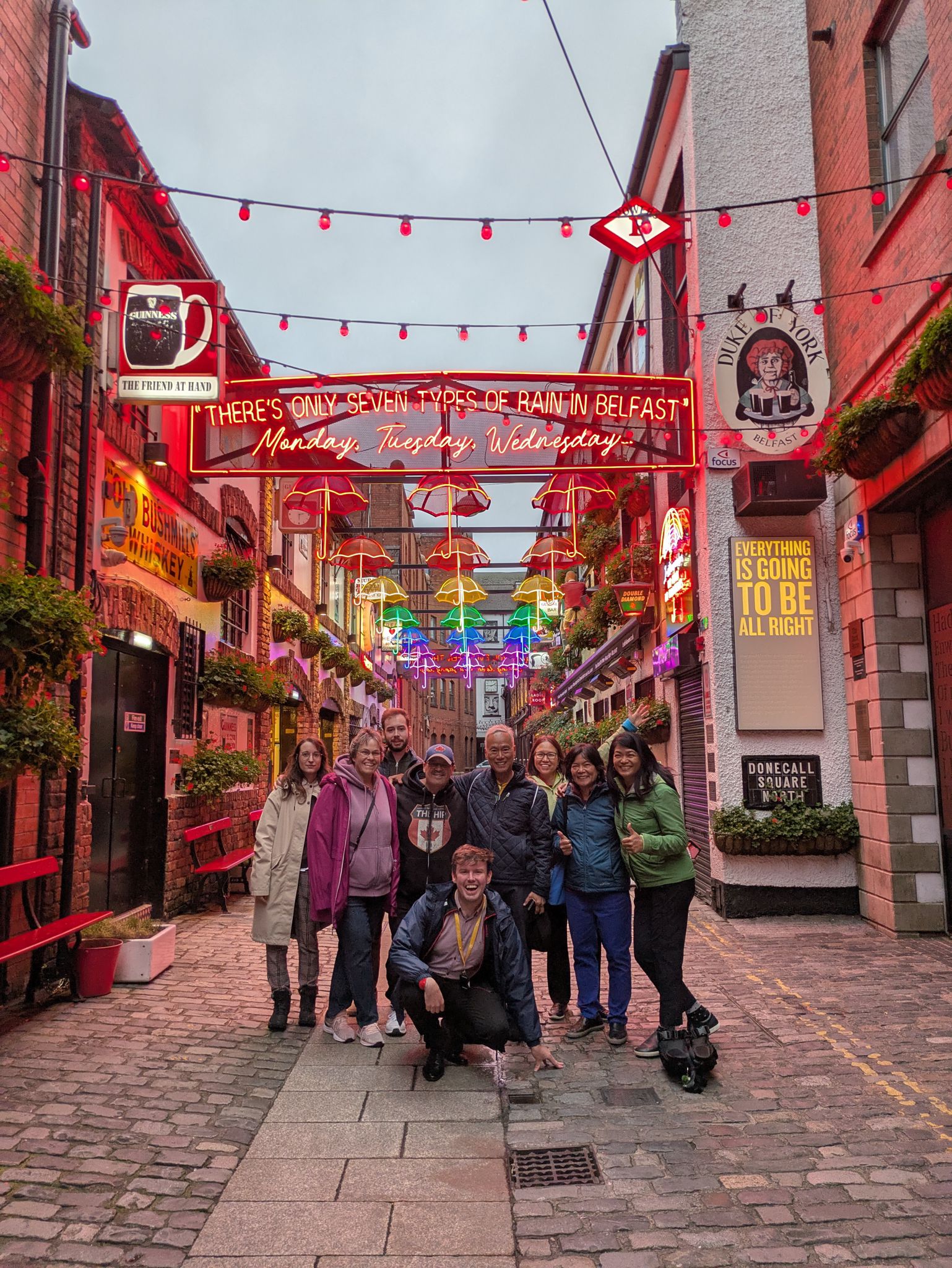 Free Walking Tour group under the umbrellas of Commercial Court, Belfast